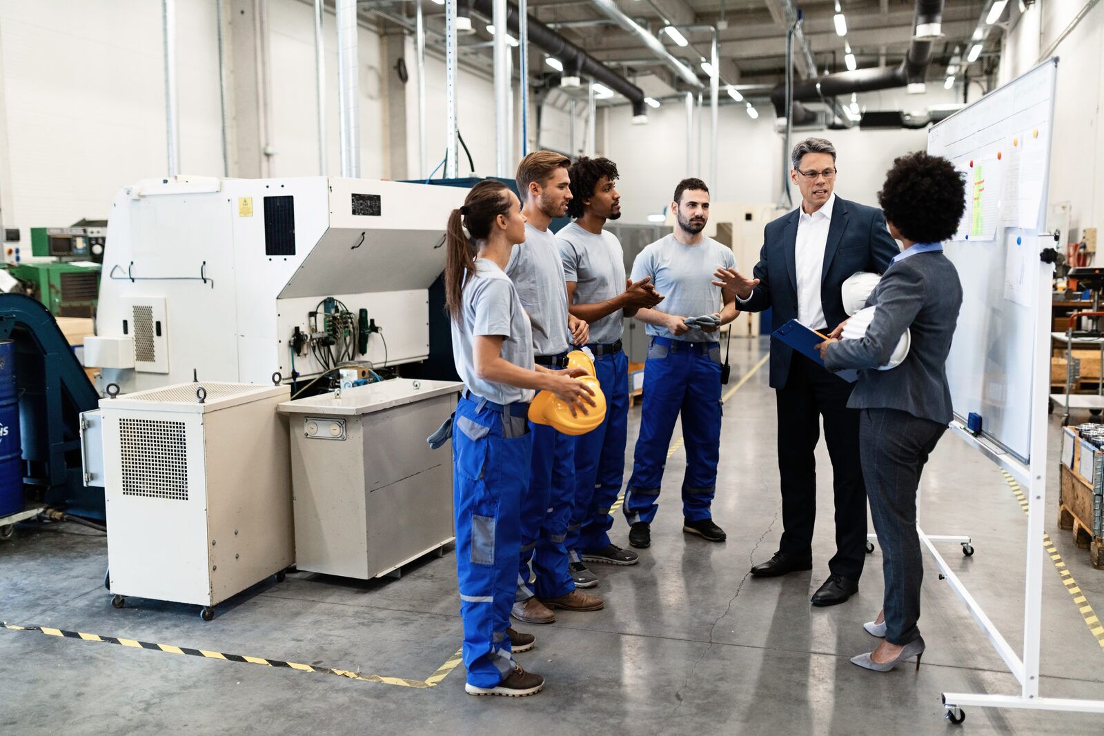 Quality control inspectors meeting on a factory floor