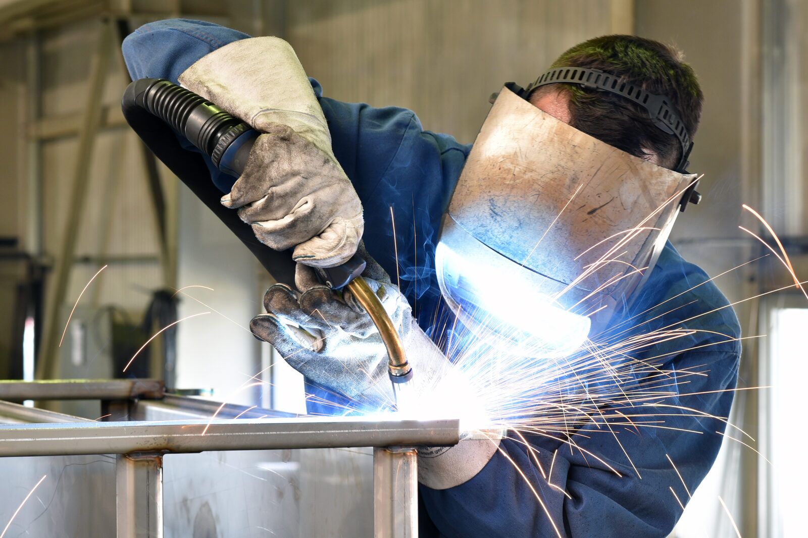 Welder working on steel components in metal construction